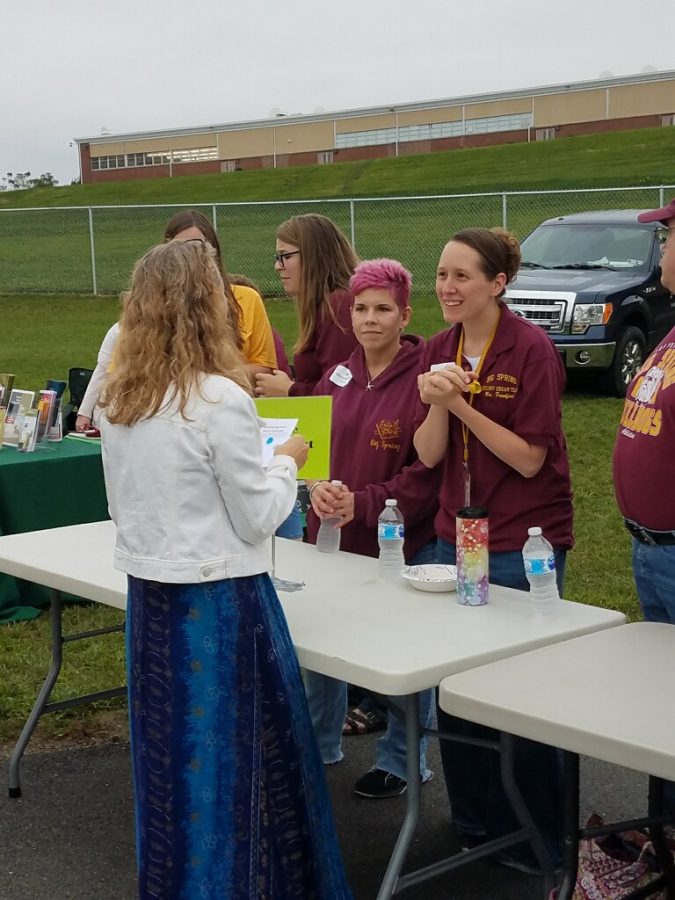 Science teachers Amanda Frankford (right) and Rebecca Herendeen (left) engage with a parent at the Back to School tailgate. The event was used for parents to connect with their childs teachers.