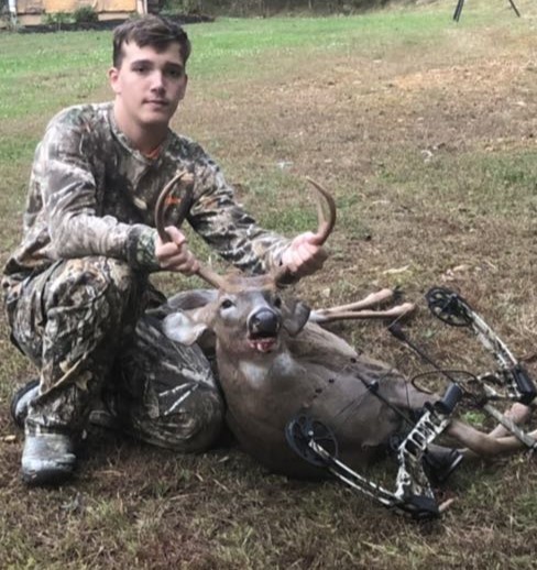 Logan posing with his kill. He shot a buck.