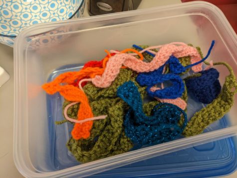 Finished hats and scarves sit in a basket waiting to be used for a snowman-making event in February. All of the items were made by the Crochet club.