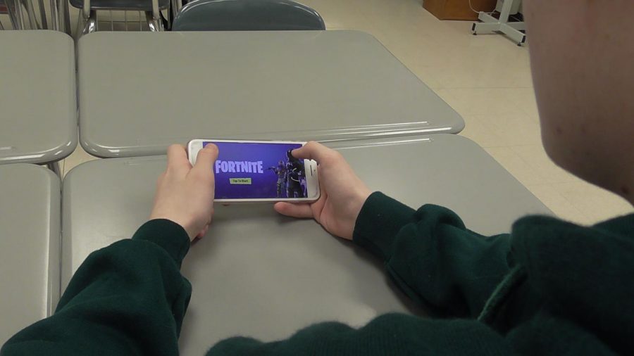 Student sits playing Fortnite during free time in class. Fortnite is the new gaming trend that a majority of people are playing. 