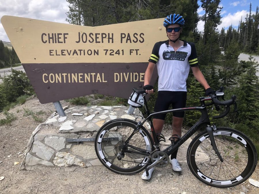 Senior Quinton Egger poses alongside a sign marking the Continental Divide. This past summer, Egger experienced the adventure of a lifetime riding his bike across the entire continental United States.