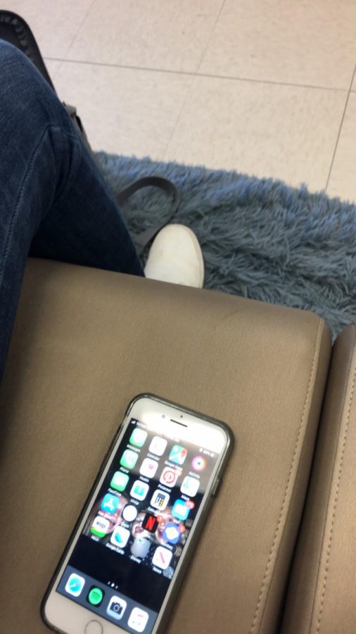 Student uses a phone to check the time during class. Phones offer many benefits to students.