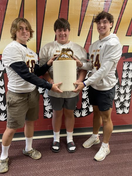 Big Spring football players Davis Moore, Logan Brennan, and Brexton Heckendorn holding the LBJ after the win