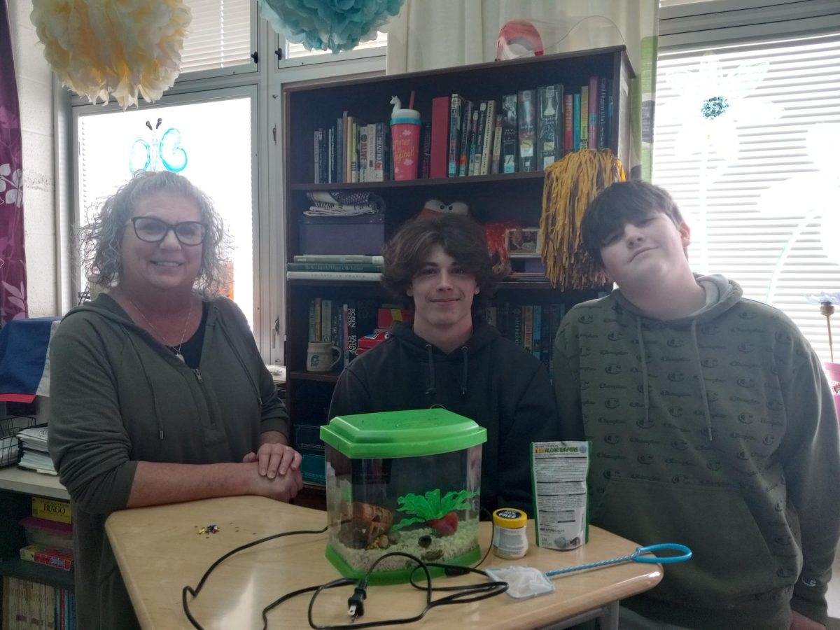 Students, Dalton Mersch and Landon Black, have created a strong bond with teacher Angelique Flory during the many flexes that they have shared. Mersch is giving his fish, used for a public speaking project, to his favorite teacher to visit during flex.